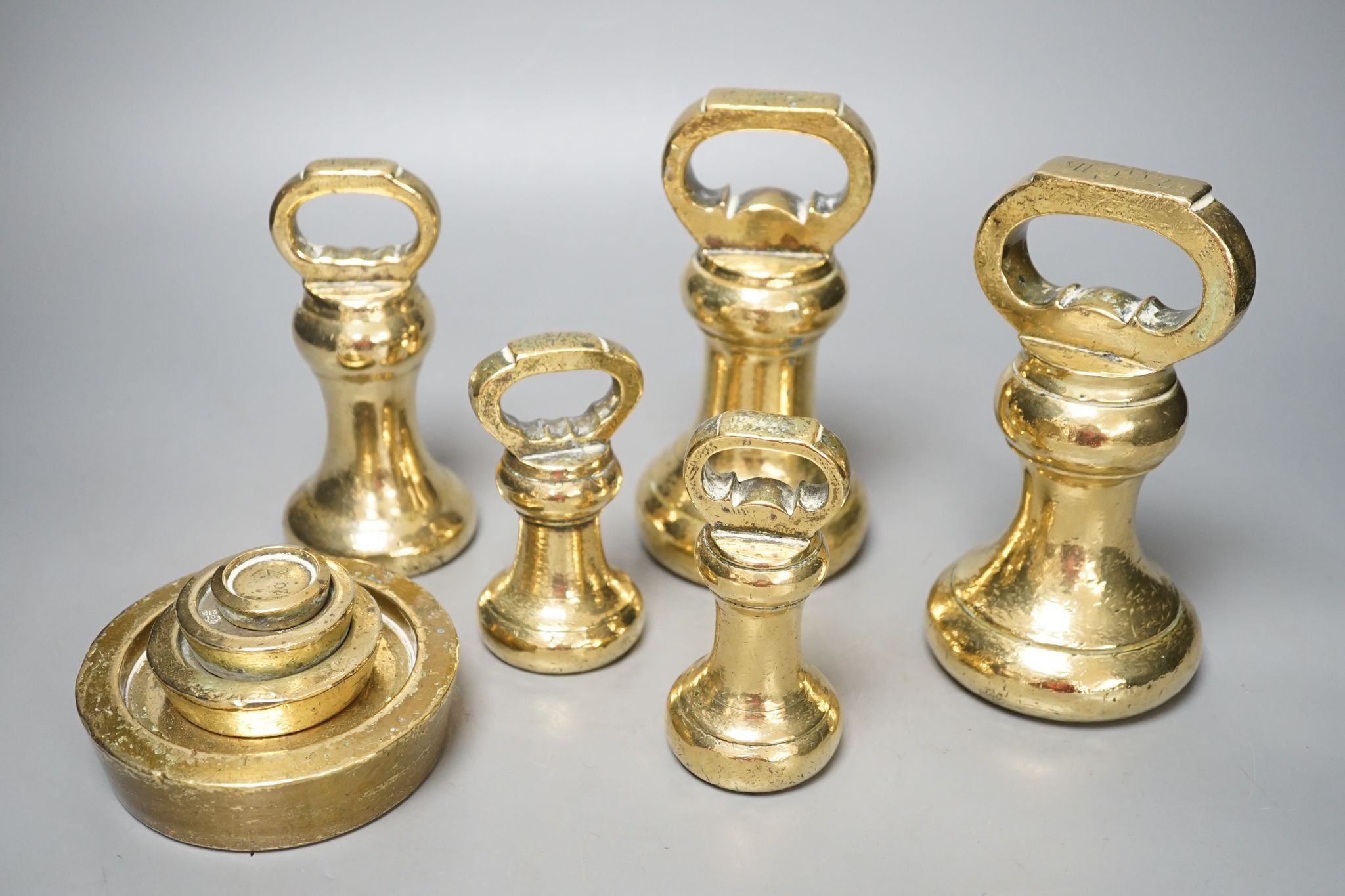 A set of 5 Victorian graduated cast brass bell weights and 3 graduated cast brass disc weights (8) 18cm